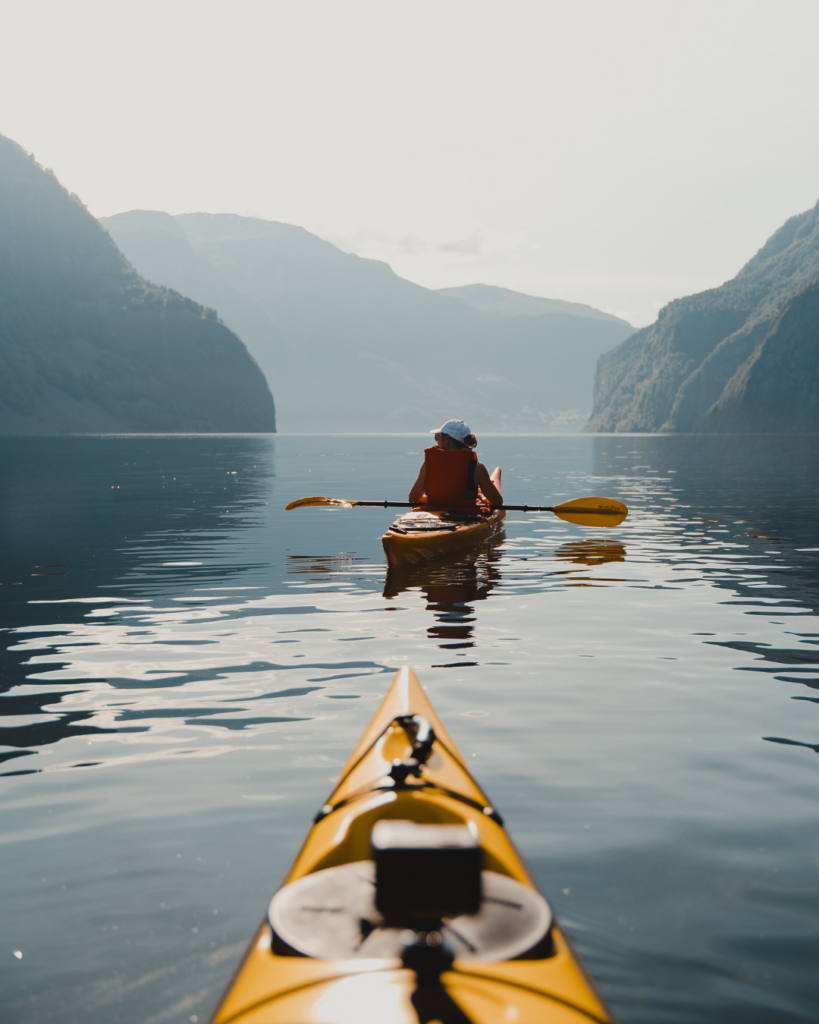 Girl kayaking in Norway in the fjords